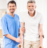 elderly man assisted by a caregiver