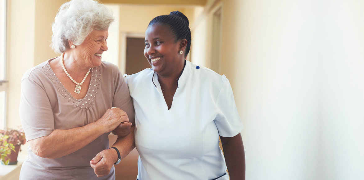 caregiver and elderly woman smiling